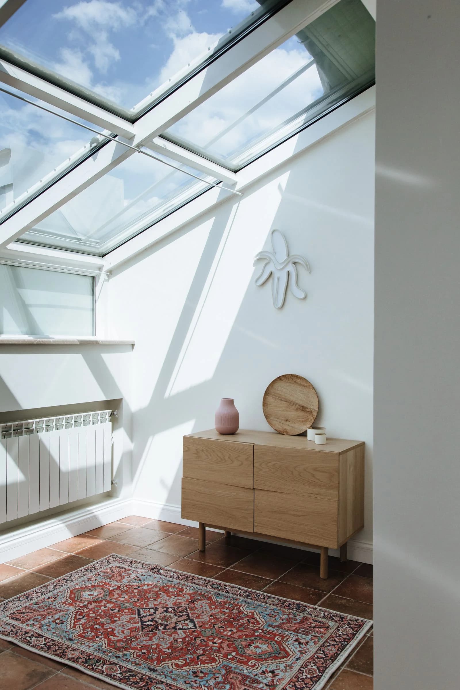 Sunlit attic with roof glazing and an oak chest of drawers — design inspiration